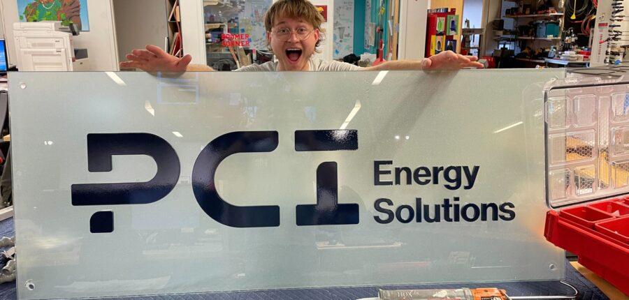 A student worker at the Innovation Hub's Fabrication Lab shows off PCI Energy Solutions' new logo.